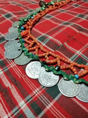 Фото 6. Низка из кораллов с монетами, закрепленная с изнанки тонкой полоски красной ткани
